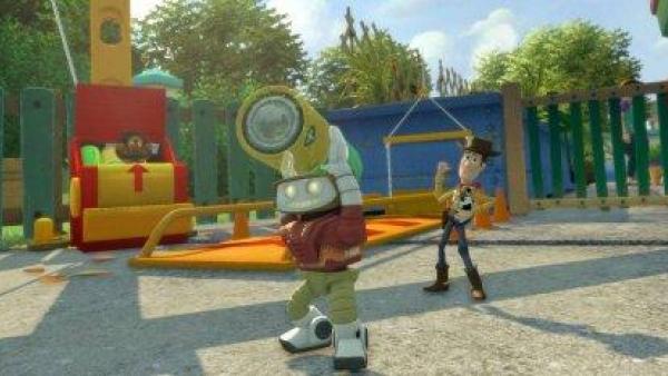 Ein Roboter hebt eine schwere Tonne über den Kopf, in Hintergrund steht der Cowboy Woody.