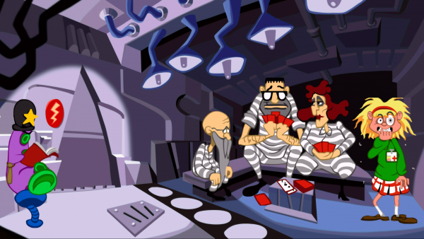 Screenshot: Drei Gefängnisinsassen sitzen beim Kartenspielen. Rechts neben ihnen steht die Hauptfigur Laverne während im linken Eck ein purpurfarbenes Tentakel als Aufpasser gekleidet in einem Buch liest. 