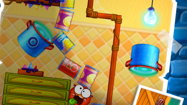 Screenshot: In einem Level in einer Küche schneiden die zwei kugelrunden Spielfiguren Grimassen.
